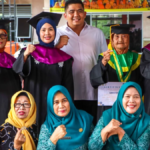 Bupati Roby Kurniawan menyerahkan toga kepada lansia di Wisuda Sekolah Lansia Bintan