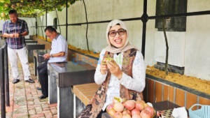 Misni picking ripe passion fruit in Ady Indra Pawennari's garden, Tanjungpinang